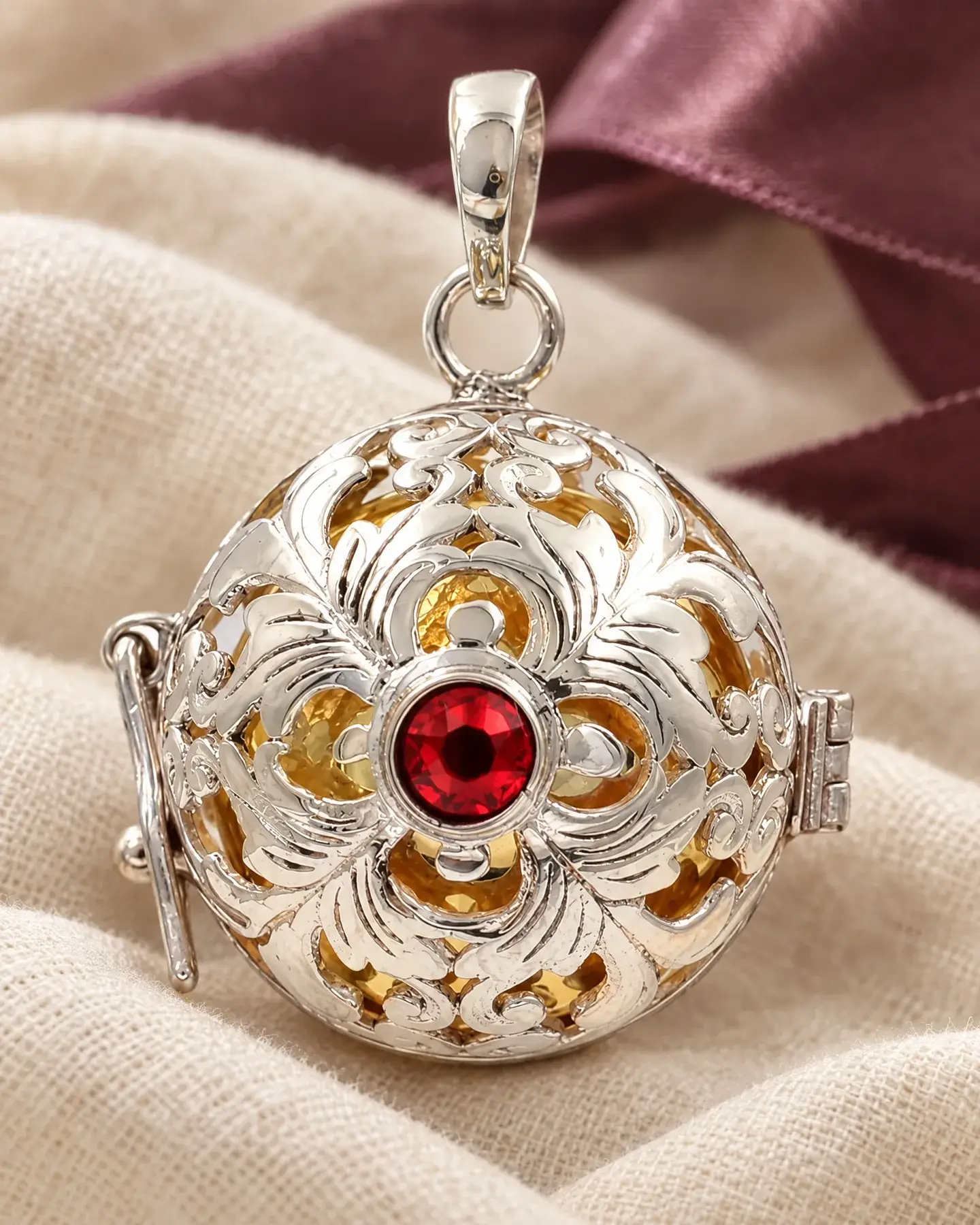 Gros plan sur le filigrane d’argent de Gita, sa pierre rouge et sa boule dorée
